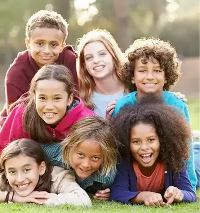 Group of foster children laying on ground and smiling