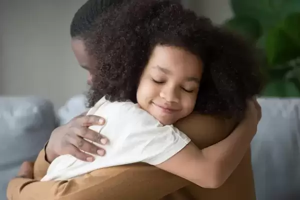 Foster Father hugging foster daughter wearing a white shirt
