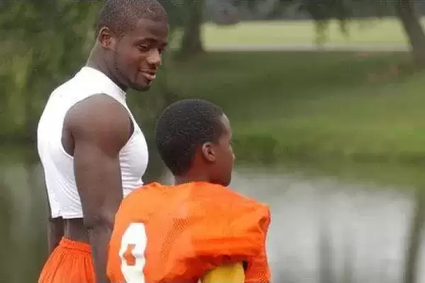 Kinship brother and guardian in football uniform by lake