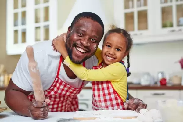 Foster father and child in kitchen cooking