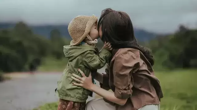 foster parent kissing a child