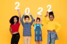 four Kids holding up 2022 in numbers on a yellow background