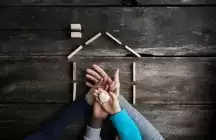 A family of four placing hands one on top of the other