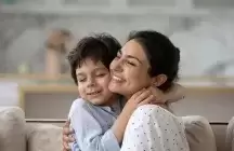 A foster mom cuddling foster kid son, showing tender feelings