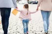 Couple walking a foster child down a street