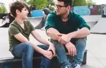foster son sitting on curb with foster dad 