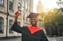 African American teen in cap and gown holding diploma 