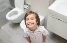 Young boy standing in a bathroom