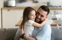 Close up smiling loving young foster father hugging adorable little foster daughter