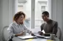 Couple sitting at a desk with a laptop