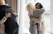 Family hugging in front of a window