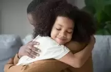 Foster Father hugging foster daughter wearing a white shirt