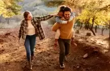 Foster family with small foster child hiking outdoors in autumn nature