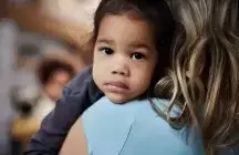 Foster girl being consoled by her adopted mother at home
