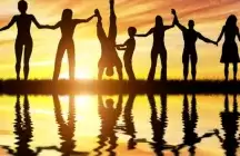 Family gathering at a beach with a sunset with everyone holding hands