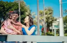 2 foster parents with a young child in the mans arms
