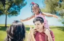 Foster child sitting on foster dad's shoulders 