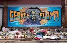 A memorial to George Floyd wall art and flowers