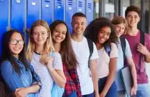 Group of teens standing in front of blue lockers 