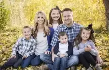 Foster Family of six sitting in the woods