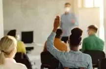 Foster parents in a training class with one person with hand up
