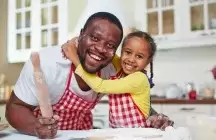 Foster father and child in kitchen cooking