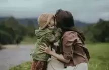 Foster mother hugging a foster child by a road