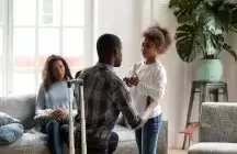Foster parents talking to a child in living room