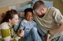 Two parents of a foster child sitting down on the floor
