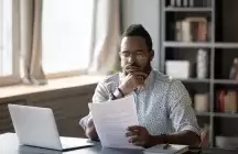 Male social worker reading a report at a desk