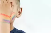 childs hand and face with a rainbow