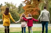 A foster family of four walking in the park