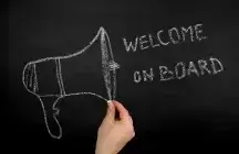 message Welcome on board and a mega phone drawn on a black board