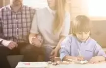 Foster parents watching a child draw