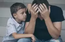 A parent holding his head with a child supporting him on a step