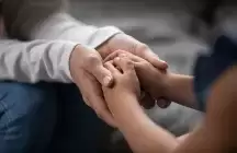 adult hands holding a foster child's hands