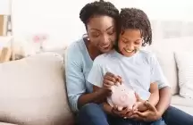 foster mom and child putting money in piggy bank
