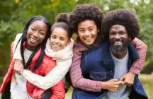 Foster parents outside with foster son and daughter 