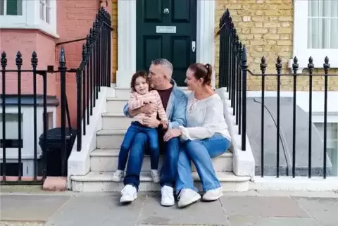 Foster Mom and Dad sitting on steps with child