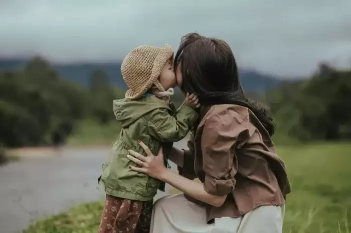 foster parent kissing a child